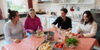 vier mensen aan tafel in keuken