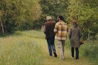 drie personen wandelen in grasvlakte